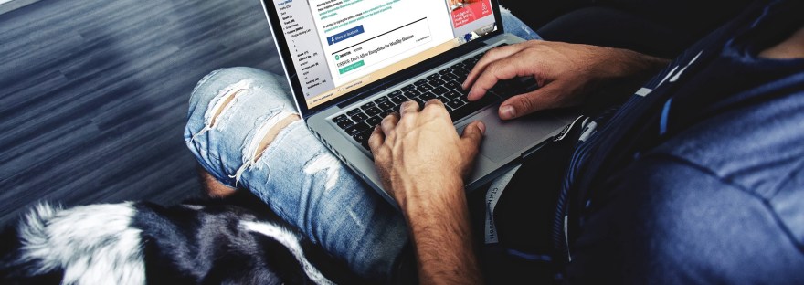 Man with laptop and a dog